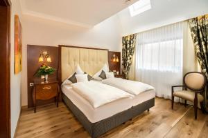 um quarto com uma cama grande e uma cadeira em Residence Bellevue em Boppard