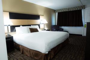 a hotel room with a large bed and a chair at Eastern Inn in Bourne