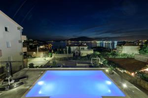 una piscina illuminata di notte su un tetto di Villa Gala a Trogir