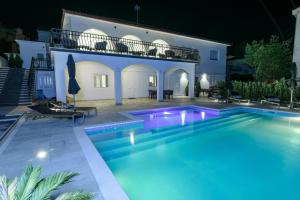 una piscina di fronte a una villa di notte di Villa Gala a Trogir