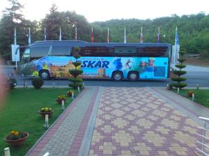 er staat een bus geparkeerd op een parkeerplaats bij Hotel Nar Gevgelija in Gevgelija