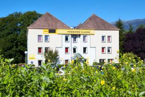 un bâtiment blanc avec un panneau indiquant un hôtel dans l'établissement Premiere Classe Geneve - Saint Genis Pouilly, à Saint-Genis-Pouilly