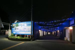 een gebouw met een groot bord aan de zijkant 's nachts bij Hotel Kilala (Adult Only) in Koriyama