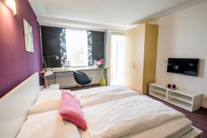 a bedroom with a large bed and a window at College Garden Hotel in Bad Vöslau