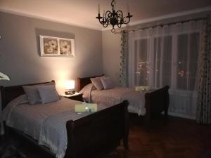 een slaapkamer met 2 bedden, een tafel en een raam bij CasaMatta in Viña del Mar