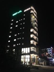 洞海Windy Hotel Quang Binh的一座有灯的建筑,上面有哈雷酒店标志