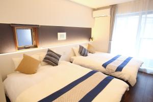 Apartment Hotel Tenjin TUMUGU 객실 침대