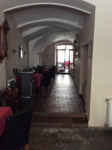 a long hallway with tables and chairs in a restaurant at Hotel U Zlateho Andela in Pardubice