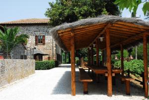 um pavilhão de madeira com um banco e um telhado de relva em Il Castagno Toscana em Campiglia Marittima