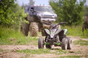 een vierwieler op een onverharde weg met een jeep op de achtergrond bij Penzion Lesni in Milovice