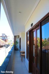 um edifício com uma varanda com uma mesa e bancos em Dana Homestay em Canggu