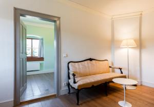 Cette chambre comprend une chaise, une table et un miroir. dans l'établissement Schloss Ettersburg Weimar, à Ettersburg