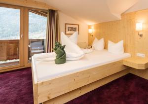 um quarto com uma cama com um bicho de peluche sentado nela em LifestylePanoramaHotel Erika Superior em Neustift im Stubaital