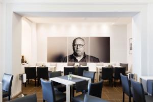 un restaurant avec une photo d'un homme sur le mur dans l'établissement Schloss Ettersburg Weimar, à Ettersburg