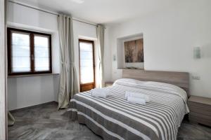 a bedroom with a bed with a striped blanket at Casa delle rose in Verbania