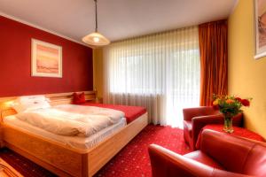 a hotel room with a bed and two chairs at Hotel Katharina Garni in Tübingen