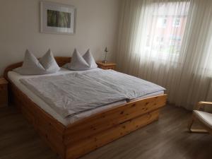 een slaapkamer met een houten bed met witte lakens bij Ferienhaus Am Yachthafen in Rendsburg