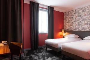 a hotel room with two beds and a window at Hôtel Bristol Reims in Reims