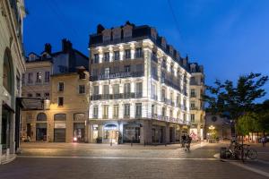 un edificio en una calle de la ciudad por la noche en Hôtel de l'Europe Grenoble hyper-centre, en Grenoble