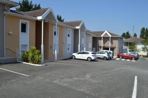 a row of houses with cars parked in a parking lot at Hotel Formule Club in Cenon