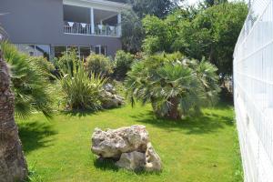 a garden with a large rock in the grass at Hotel Formule Club in Cenon