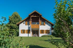 une maison blanche avec un toit en bois sur une colline dans l'établissement Villa Anna Bad Goisern am Hallstättersee, à Bad Goisern