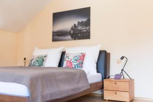 - une chambre avec un lit doté de draps et d'oreillers blancs dans l'établissement Villa Anna Bad Goisern am Hallstättersee, à Bad Goisern