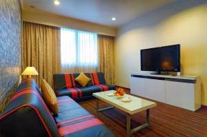 a living room with a couch and a flat screen tv at Hotel Shangri-la Kota Kinabalu in Kota Kinabalu