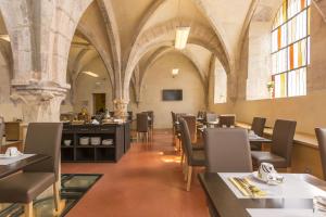 un comedor con mesas y sillas en un edificio en Odalys City Dijon Les Cordeliers, en Dijon