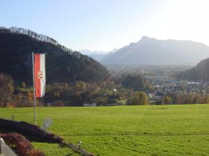 a flag on top of a green field with mountains at Hotel Schöne Aussicht in Salzburg