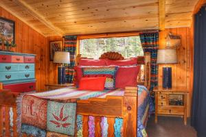 - une chambre avec un lit dans une cabane en bois dans l'établissement Pine Haven Resort, à Estes Park