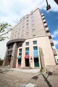 d'un grand bâtiment avec un auvent rouge dans l'établissement Hotel Quest Shimizu, à Shizuoka