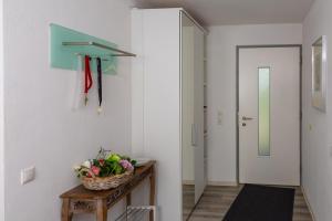 un corridoio con un cesto di fiori su un tavolo accanto a una porta di Ferienwohnung im Paradiesgarten a Deidesheim