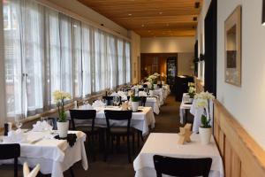 una fila de mesas en un restaurante con mesas blancas en Hotel & Restaurant STERNEN MURI bei Bern, en Berna