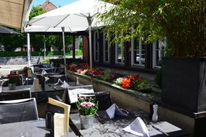 un restaurante al aire libre con mesas y sillas con flores en Hotel & Restaurant STERNEN MURI bei Bern, en Berna