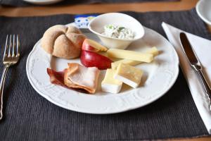 un plato de comida con queso, fruta y pan en Hotel & Restaurant STERNEN MURI bei Bern, en Berna