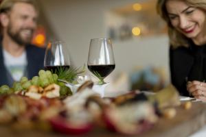 una mujer y un hombre sentados en una mesa con copas de vino en Grand Hotel Admiral Palace, en Chianciano Terme