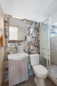 a bathroom with a toilet and a sink and a shower at Takis Family Corfu in Kontokali