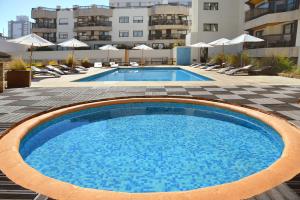 uma grande piscina com cadeiras e um edifício em Golden Beach Resort & Spa em Punta del Este