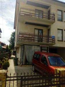 een rood busje geparkeerd voor een huis bij Vila Veronika in Ohrid