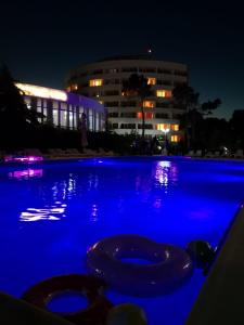 a swimming pool with blue lighting in front of a building at Hotel Scoica in Jupiter