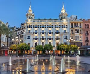 um edifício com fontes de água em frente em H10 Palacio Colomera em Córdoba