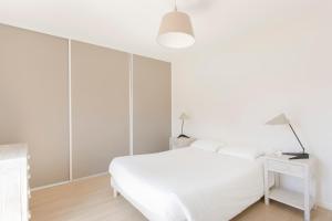 een witte slaapkamer met een wit bed en een bureau bij Zenao Appart'hôtels Troyes in Troyes