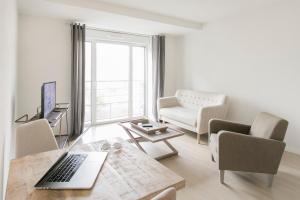 een woonkamer met een laptop op een houten tafel bij Zenao Appart'hôtels Troyes in Troyes