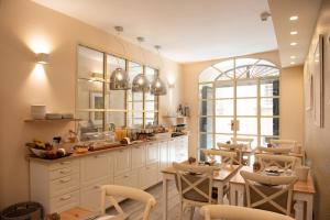 een keuken met witte kasten en stoelen en een tafel bij B&B Residenza Di Via Fontana in Lucca