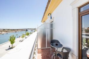 einen Balkon mit Blick auf das Wasser in der Unterkunft Residencial Mares in Tavira