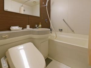 ein Badezimmer mit einem weißen WC und einem Waschbecken in der Unterkunft Hotel Sunroute Sopra Kobe in Kōbe