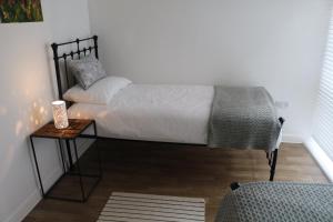 a bedroom with a bed and a table and a chair at City Apartment in Winchester