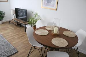 a dining room with a wooden table and white chairs at City Apartment in Winchester