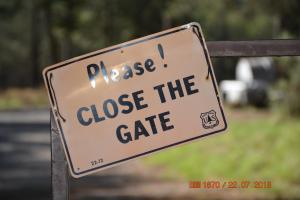 a sign that says please close the gate at Sitzmark Chalet Inn in Ruidoso